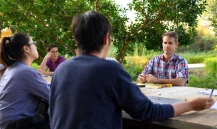 Cameron Shelton and students at a table