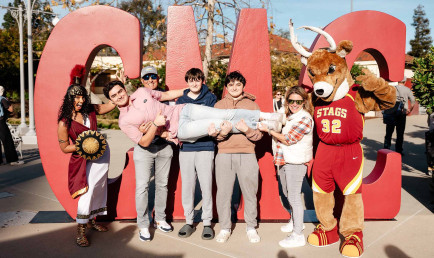 Group of students in front of large CMC signs