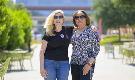 Mari Adam ’80 (left) and Lorraine Bains ’88 standing together on the North Mall.