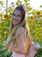 Photo of Ari Livi in a field a sunflowers.