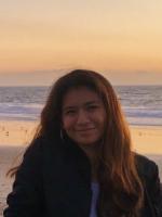 Photo of Emily Ortiz at a beach during an orange sunset.