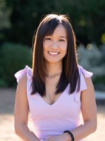 Photo of Claire Chen outdoors with green shrubbery behind her.