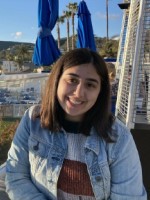 Photo of Olivia Fish dining outdoors with mountains and palm trees behind her.