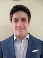 Jorge Peña photographed in a blue suit jacket and shirt against a plain white wall.