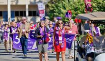 Group of people marching down the campus mall celebrating 50 Years of Co-ed at Impact weekend